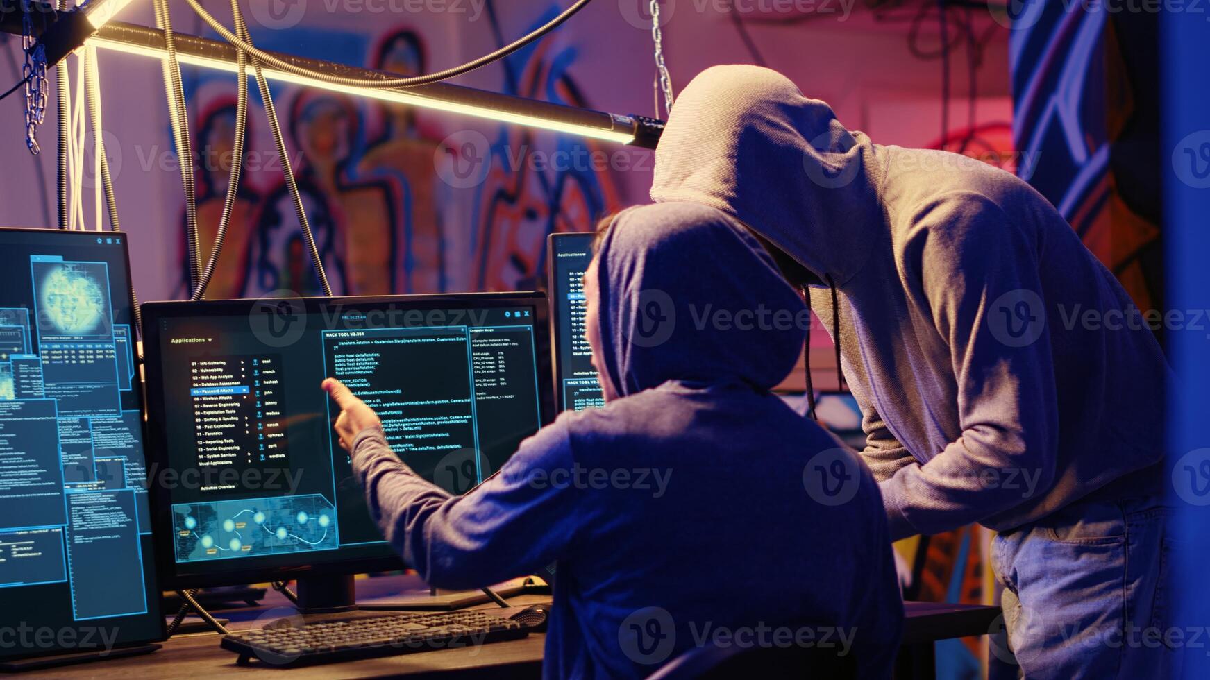Evil cybercriminals in graffiti sprayed hideaway targeting vulnerable unpatched connections, discussing ways of getting past computer defenses and stealing valuable sensitive data photo