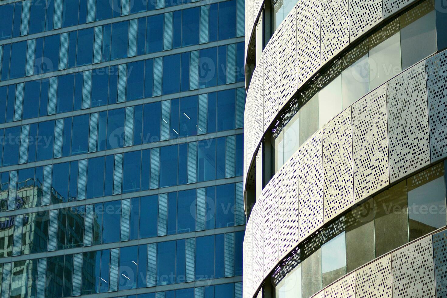 Glass building with transparent facade of the building and blue sky. Structural glass wall reflecting blue sky. Abstract modern architecture fragment. Contemporary architectural background. photo