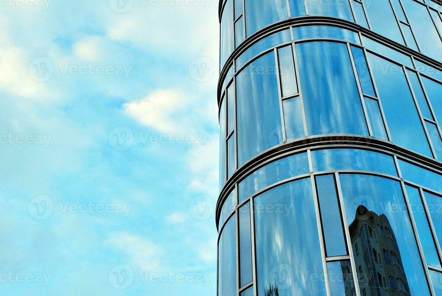 Glass building with transparent facade of the building and blue sky. Structural glass wall reflecting blue sky. Abstract modern architecture fragment. Contemporary architectural background. photo