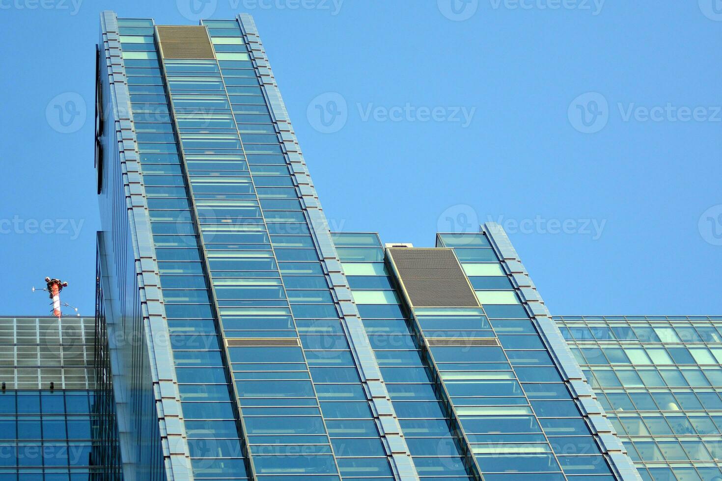 Glass building with transparent facade of the building and blue sky. Structural glass wall reflecting blue sky. Abstract modern architecture fragment. Contemporary architectural background. photo