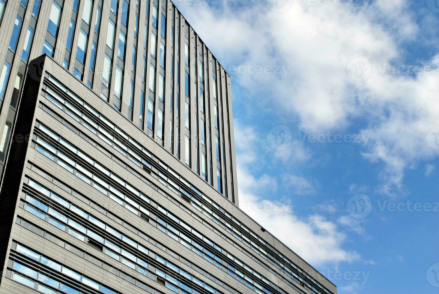 Modern office building in the city with windows and  steel and aluminum panels wall. Contemporary commercial architecture, vertical converging geometric lines. photo