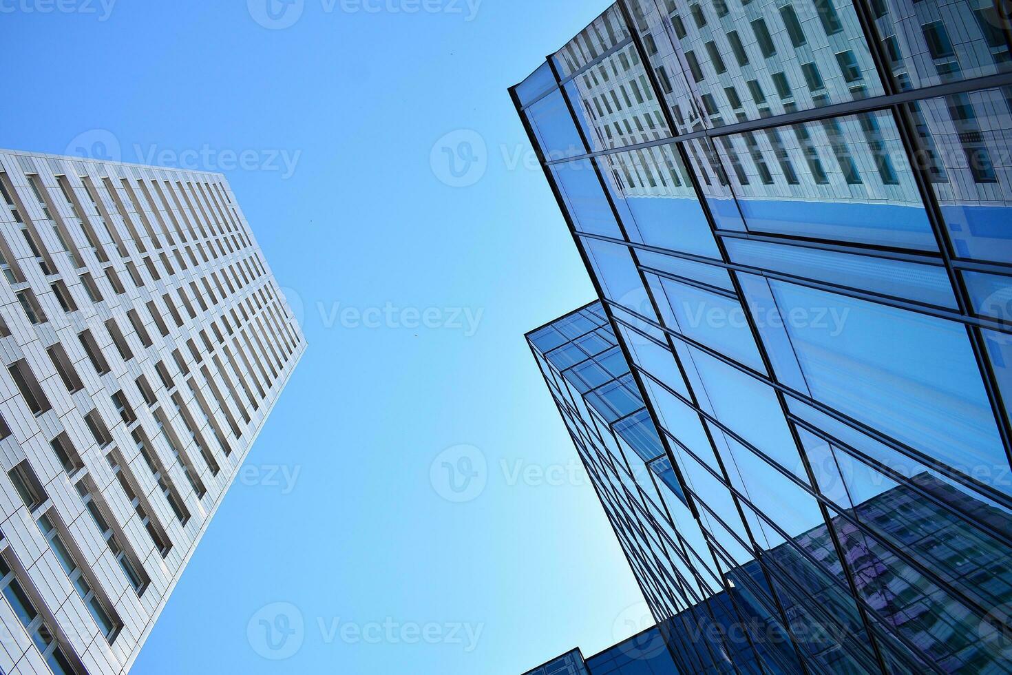 Glass building with transparent facade of the building and blue sky. Structural glass wall reflecting blue sky. Abstract modern architecture fragment. Contemporary architectural background. photo