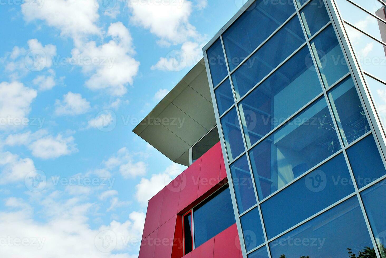 Glass building with transparent facade of the building and blue sky. Structural glass wall reflecting blue sky. Abstract modern architecture fragment. Contemporary architectural background. photo