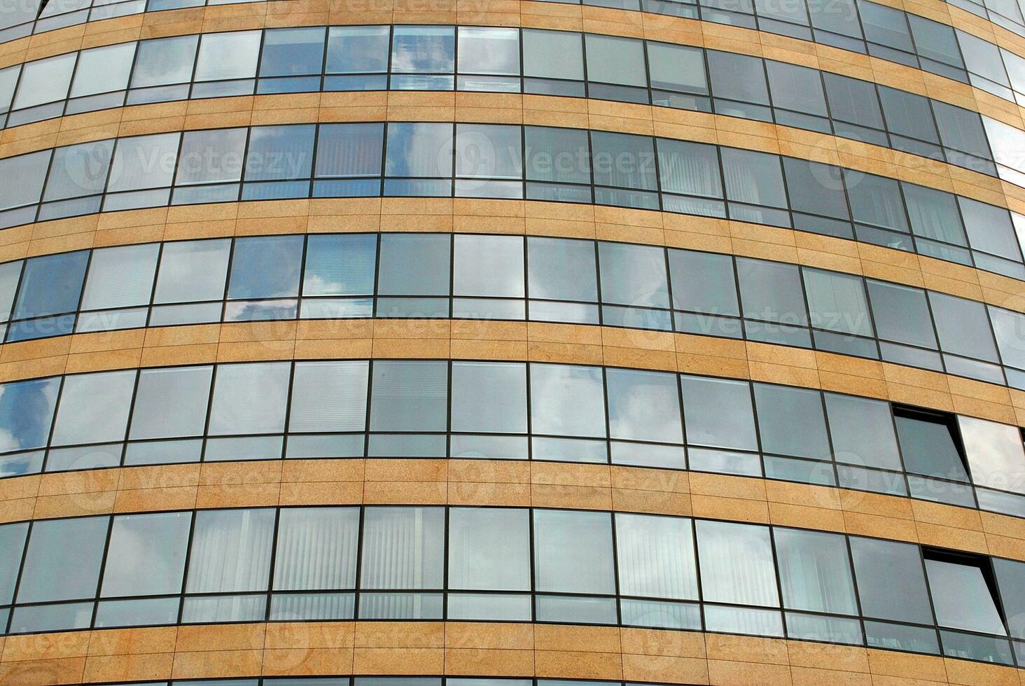 Glass building with transparent facade of the building and blue sky. Structural glass wall reflecting blue sky. Abstract modern architecture fragment. Contemporary architectural background. photo