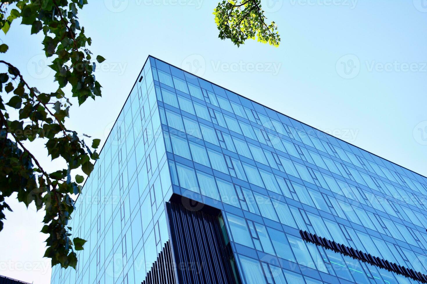 Glass building with transparent facade of the building and blue sky. Structural glass wall reflecting blue sky. Abstract modern architecture fragment. Contemporary architectural background. photo