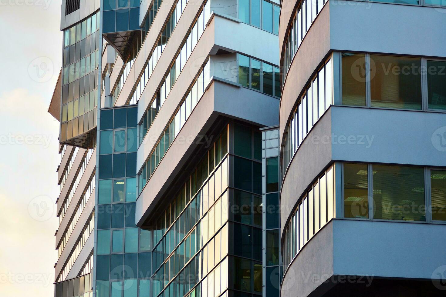 Glass building with transparent facade of the building and blue sky. Structural glass wall reflecting blue sky. Abstract modern architecture fragment. Contemporary architectural background. photo