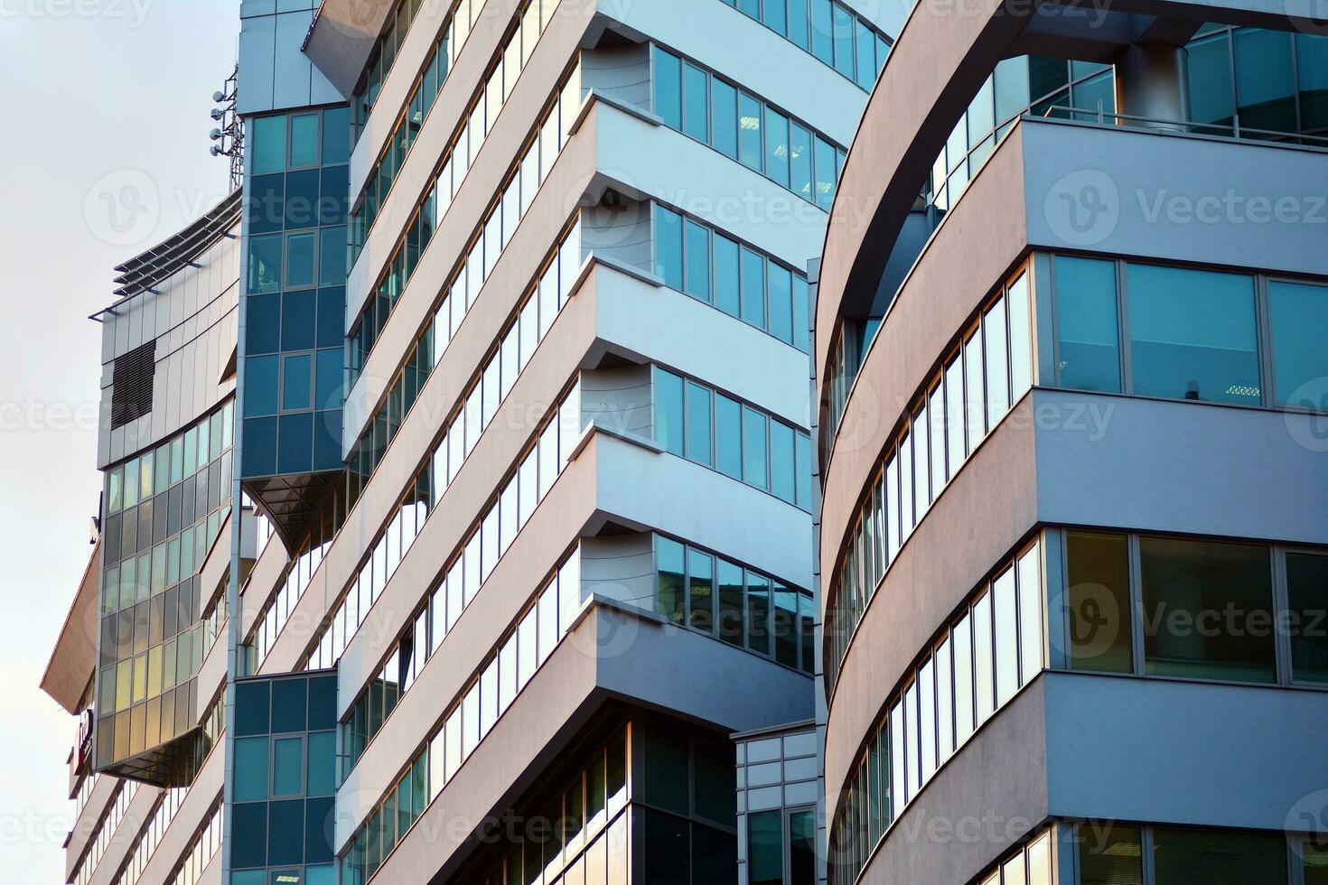 Glass building with transparent facade of the building and blue sky. Structural glass wall reflecting blue sky. Abstract modern architecture fragment. Contemporary architectural background. photo