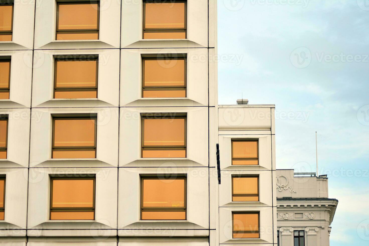 Modern office building in the city with windows and  steel and aluminum panels wall. Contemporary commercial architecture, vertical converging geometric lines. photo