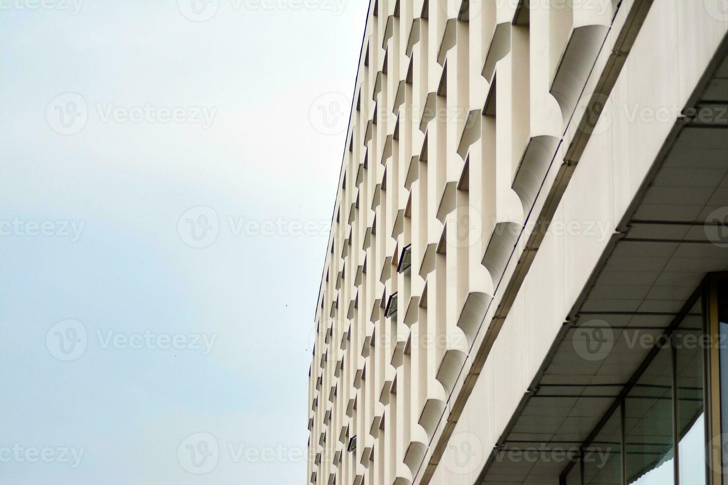 Modern office building in the city with windows and  steel and aluminum panels wall. Contemporary commercial architecture, vertical converging geometric lines. photo