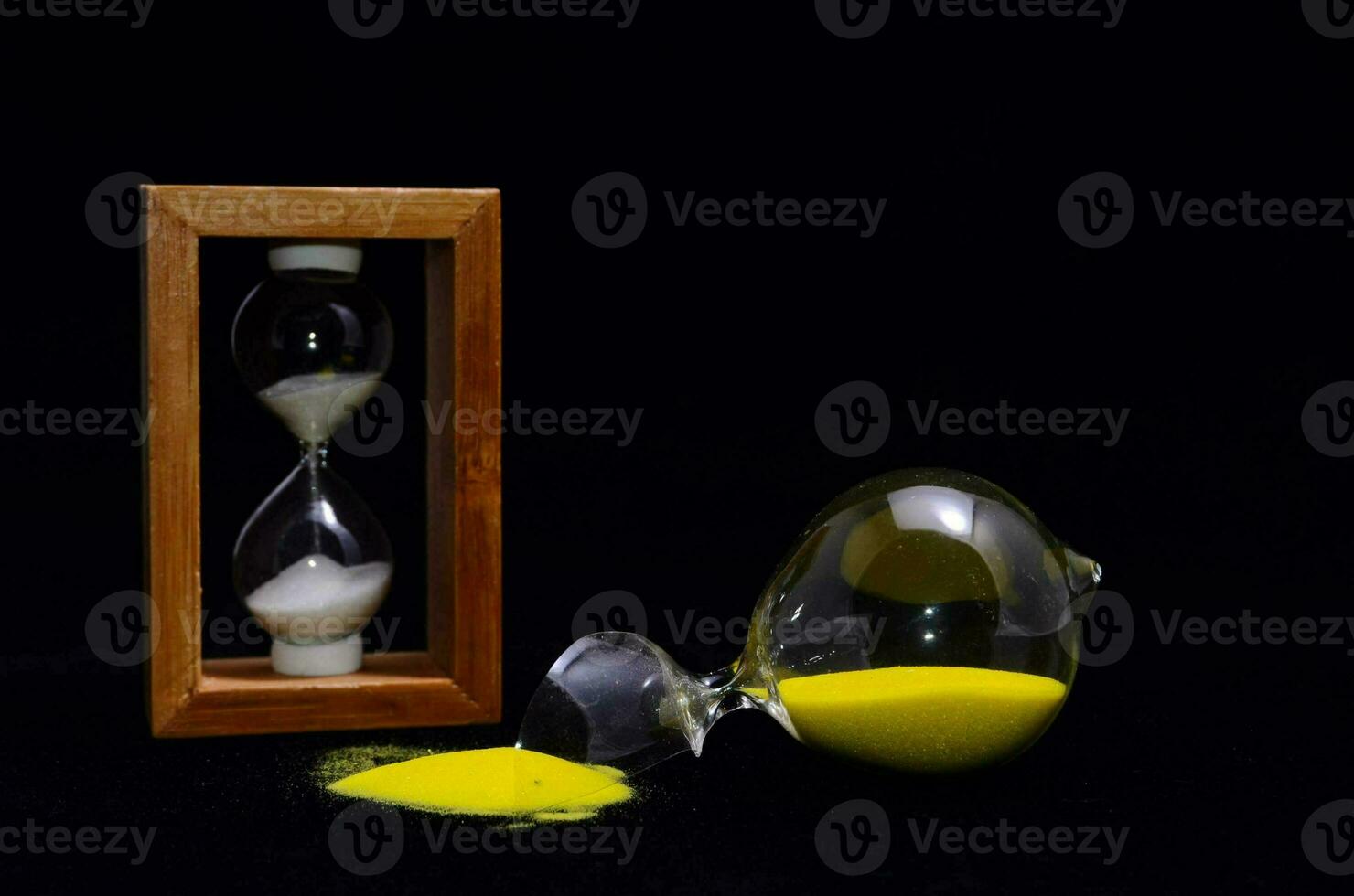 an hourglass with yellow sand and an hourglass in wooden box photo