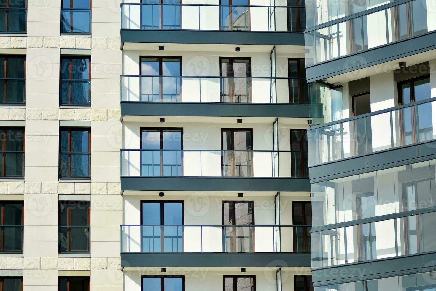 New apartment building with glass balconies. Modern architecture houses by the sea. Large glazing on the facade of the building. photo