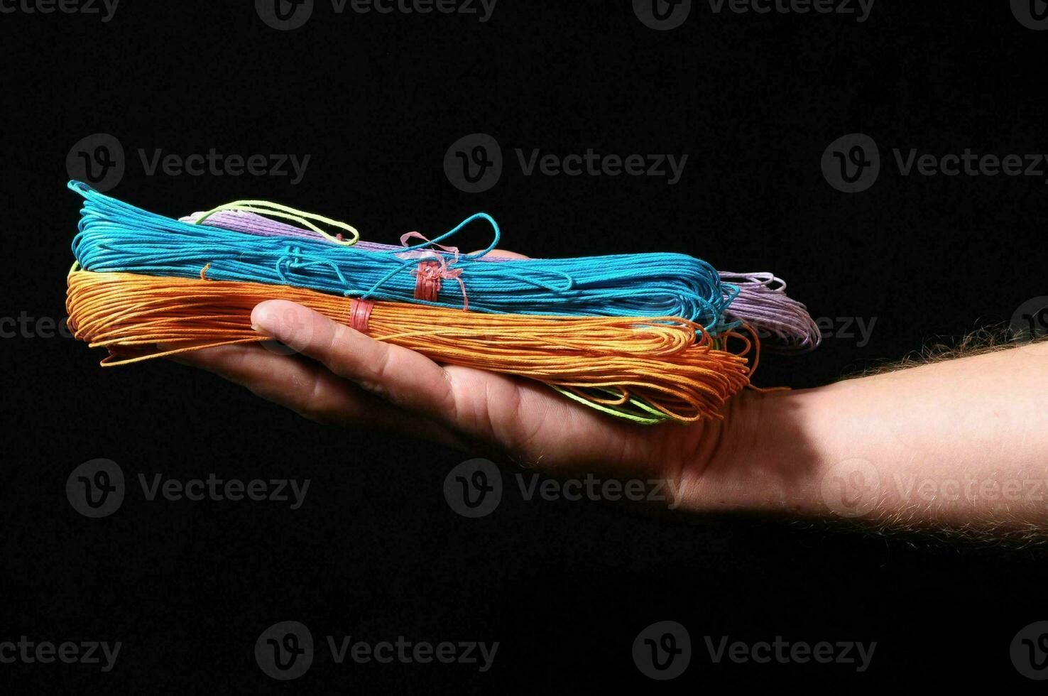 a person holding a stack of colorful string photo
