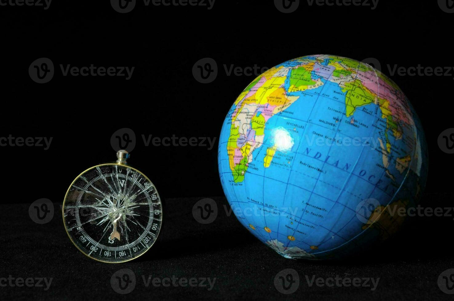 a globe and a compass on a black background photo