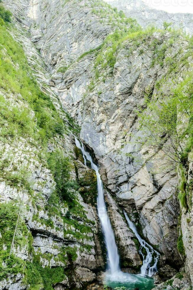 a waterfall in the mountains photo