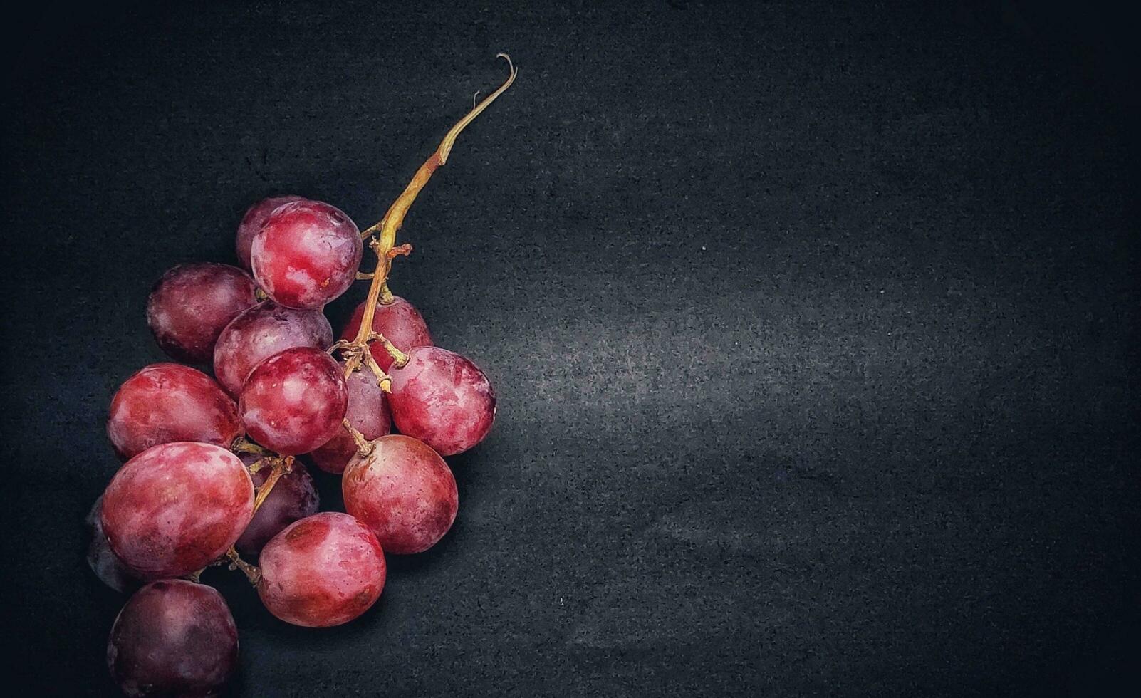 A sprig of grapes was photographed with the concept of giving a light effect to the grapes, negative space. photo