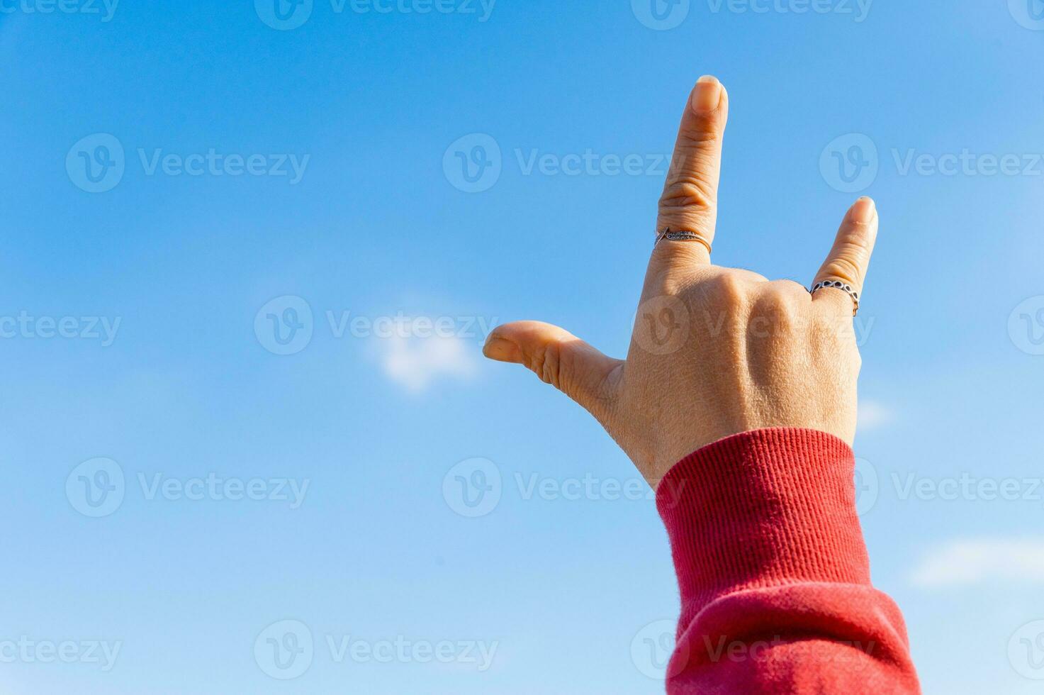 Expressive isolated hand signs 'love' against a vibrant sky, a symbolic and emotional image, ideal for romantic concepts. photo