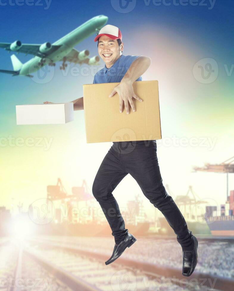 delivery man holding carton box toothy smiling face with service mind against logistic and shipping port photo