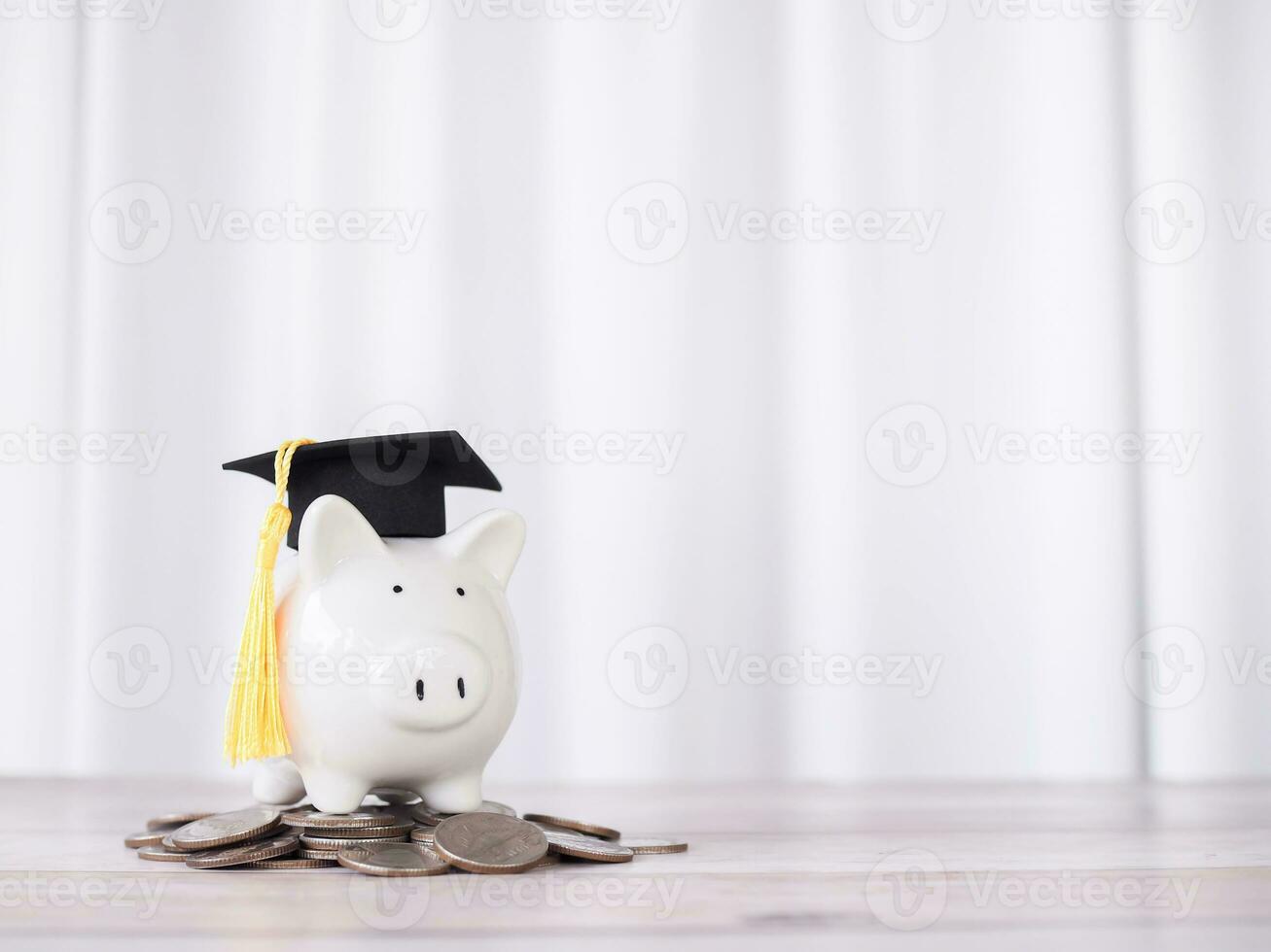 Piggy bank with graduation hat on stack of coins. The concept of saving money for education, student loan, scholarship, tuition fees in future photo