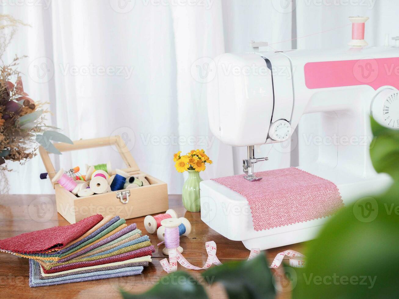 Close up of sewing machine working with red fabric,  stitch new clothing. photo