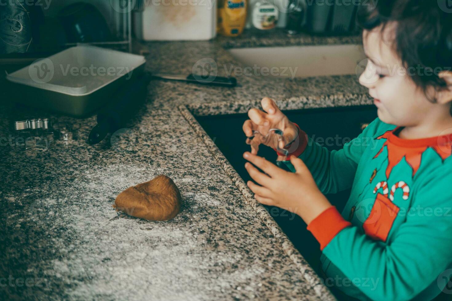 boy and his mom create special memories while preparing Christmas gingerbread for the joyful season. photo