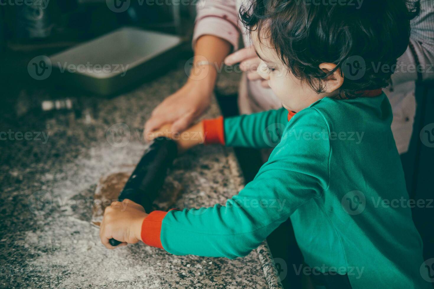 a loving mom and her son share a delightful moment preparing Christmas gingerbread. photo