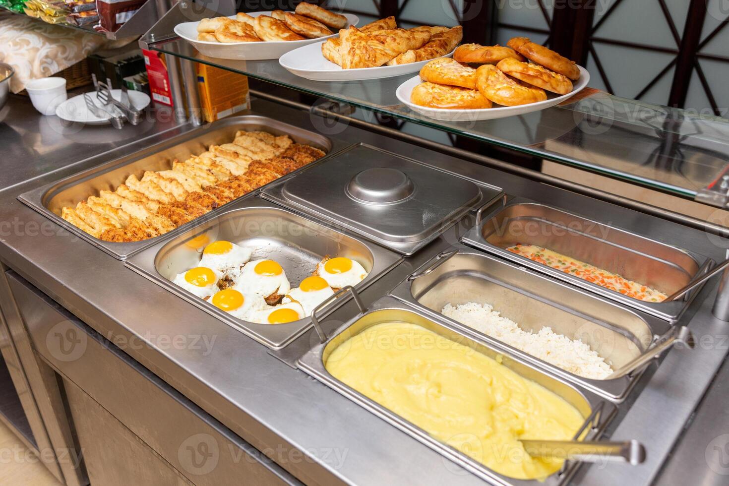 Fast food bistro, food in metal trays, cutlet salads garnish on the cafe window photo