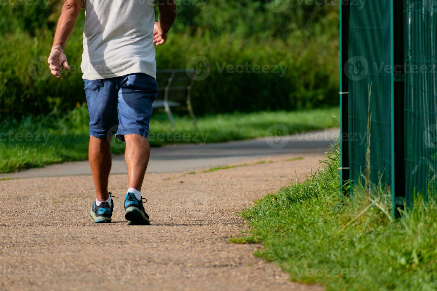 Man walking with sneakers on a path, close-up of his legs, sports activity, healthy lifetsyle photo