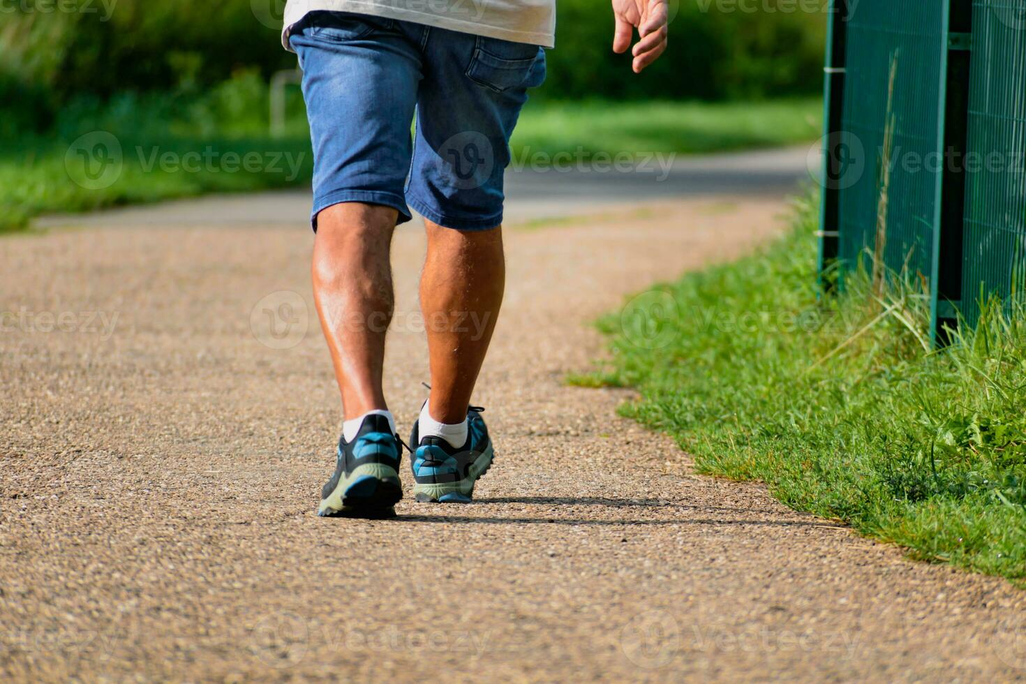 hombre caminando con zapatillas en un camino, de cerca de su piernas, Deportes actividad, sano salvavidas foto