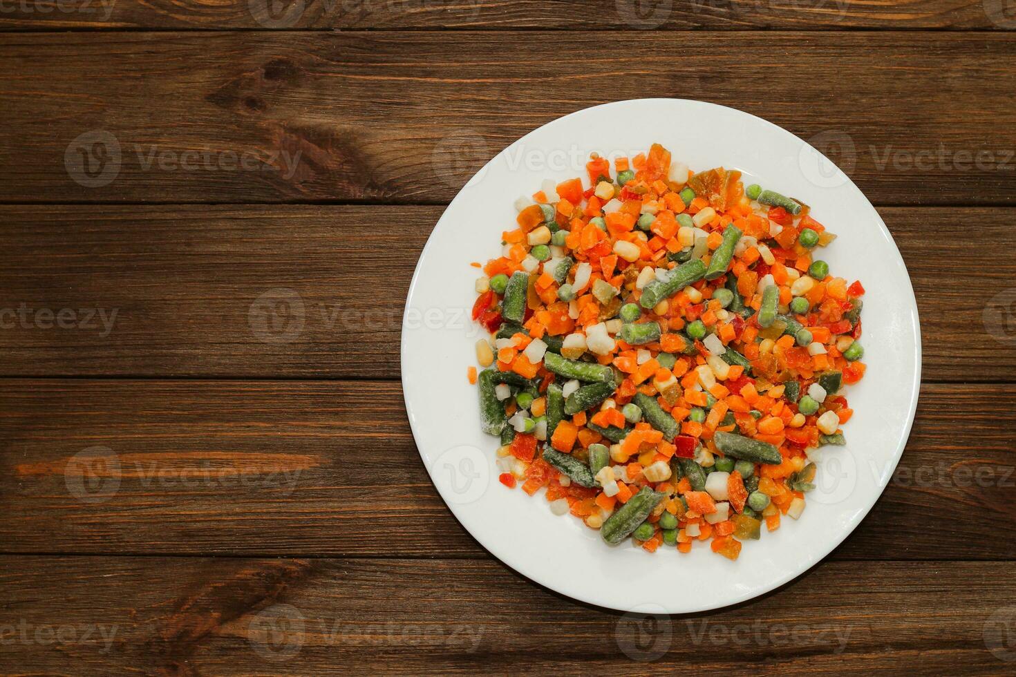 Frozen vegetables carrots, peas, beans in a plate. photo