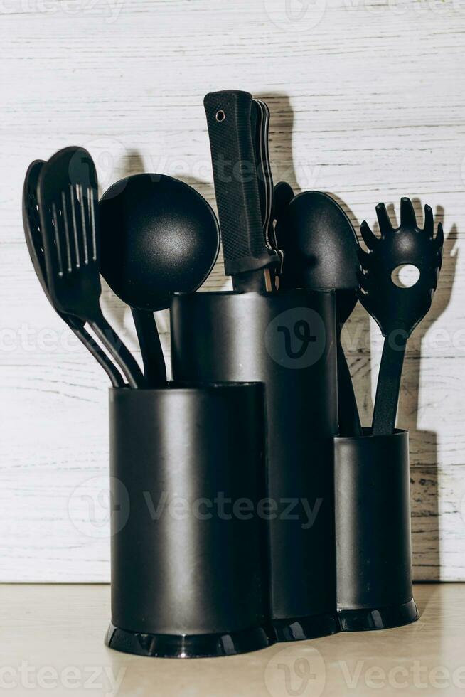 Kitchen tools plastic for multicooker on a wooden table in a dish organizer. photo