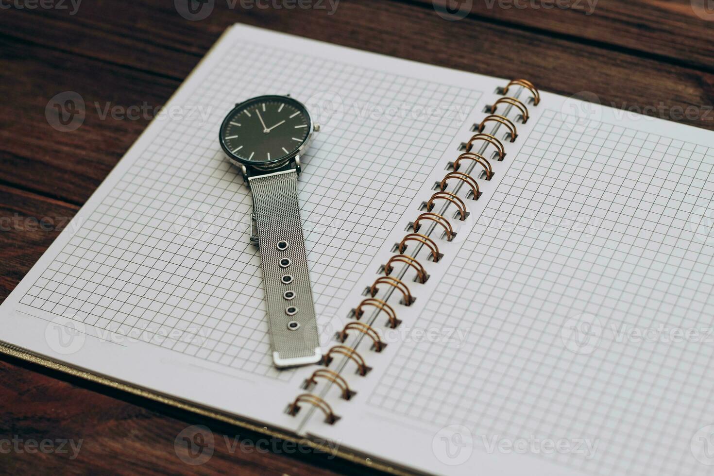 Open notebook diary with clock with black dial, time management concept. photo