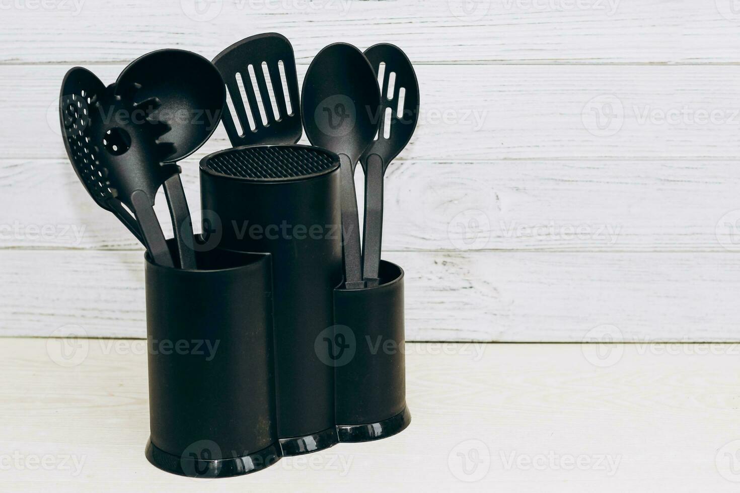 Kitchen tools plastic for multicooker on a wooden table in a dish organizer. photo