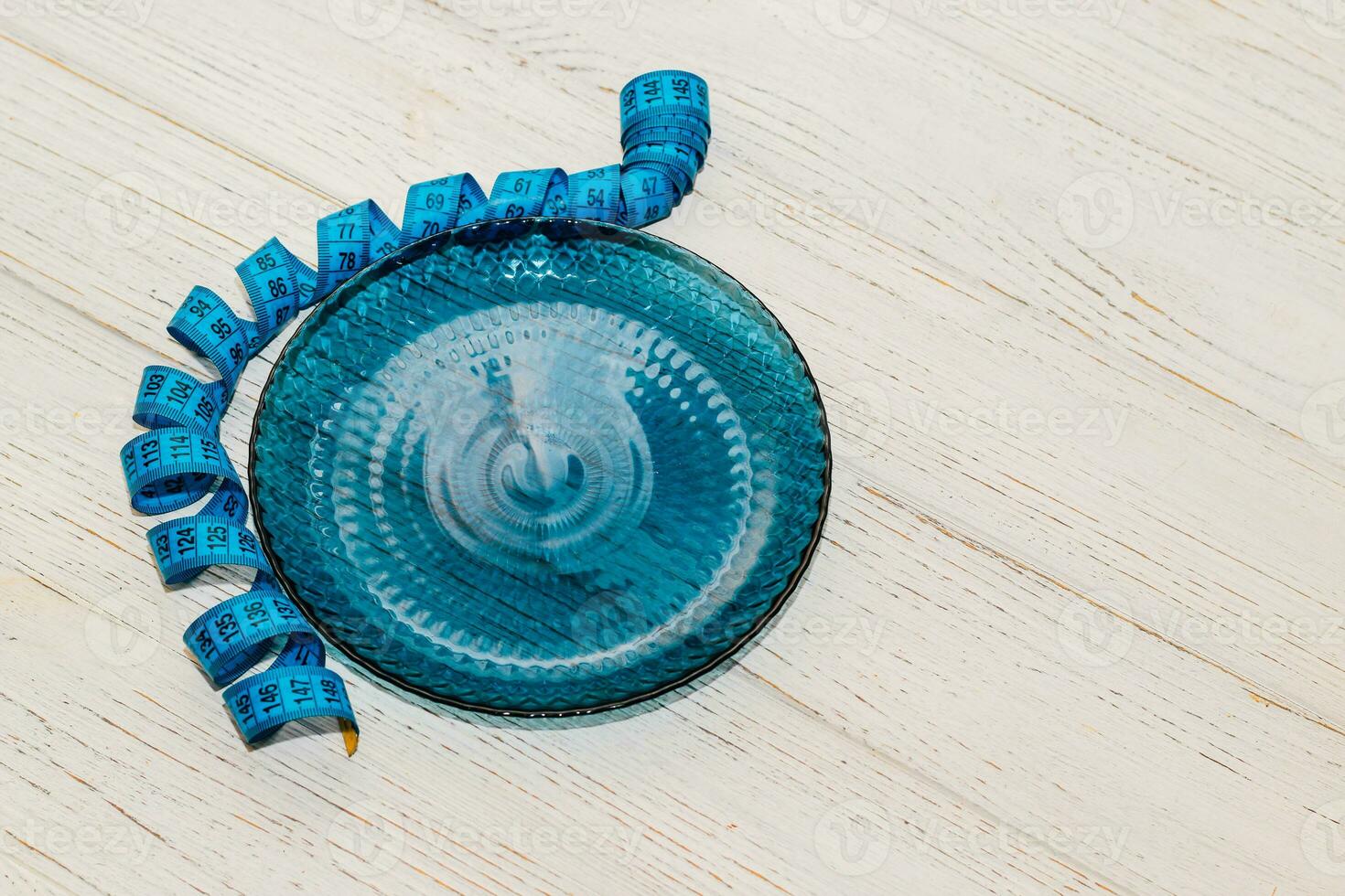 empty blue plate with centimeter on background, diet proper nutrition concept. photo