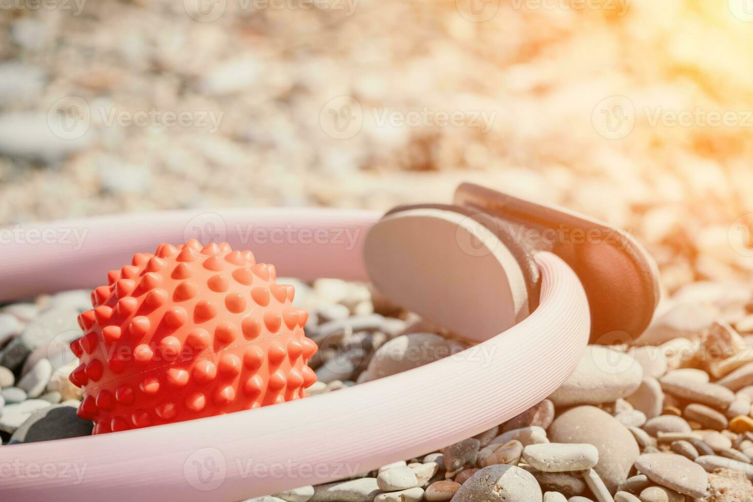 Pilates magic ring and rubber band on yoga mat near sea. Female fitness yoga concept. Healthy lifestyle harmony and meditation. photo