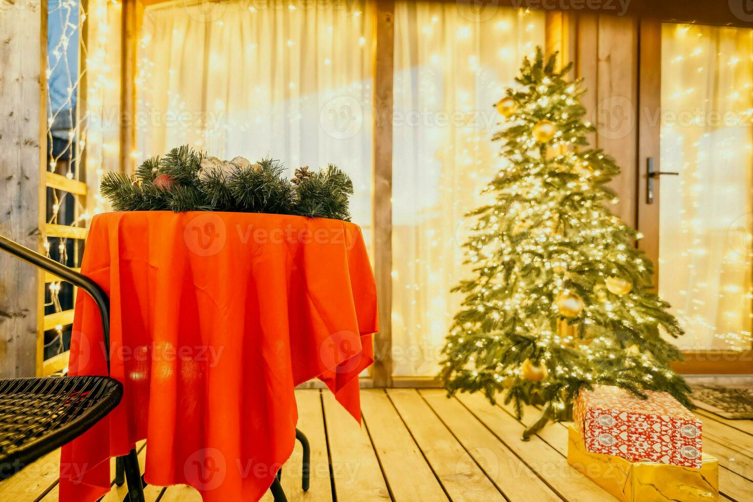 decorated Christmas tree on wooden deck, creating warm ambiance for festive occasion photo