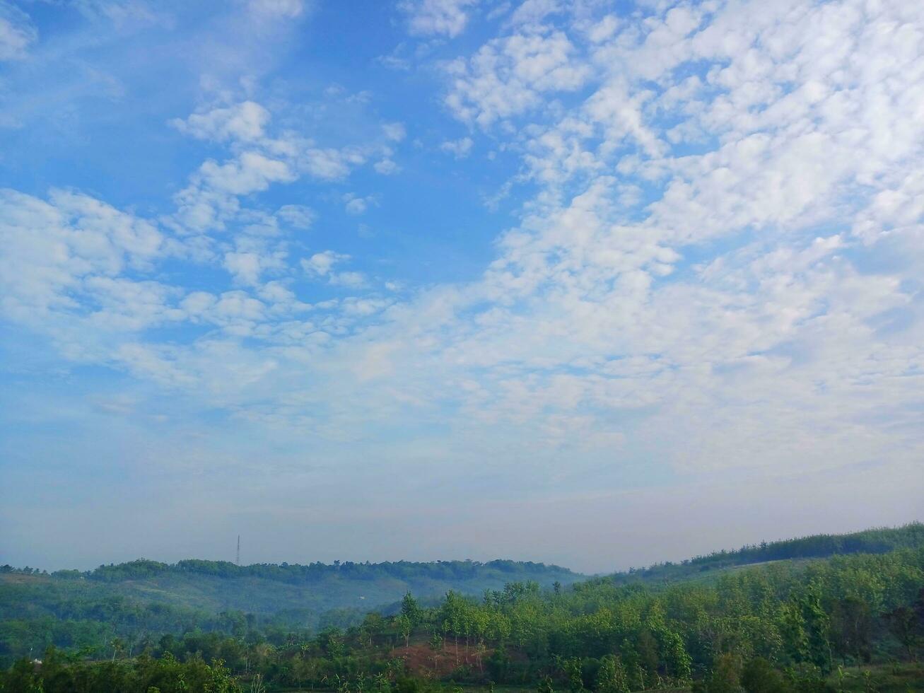 The view of the plantations is green and beautiful, there are blue clouds. See the view of the hills with blue clouds. photo