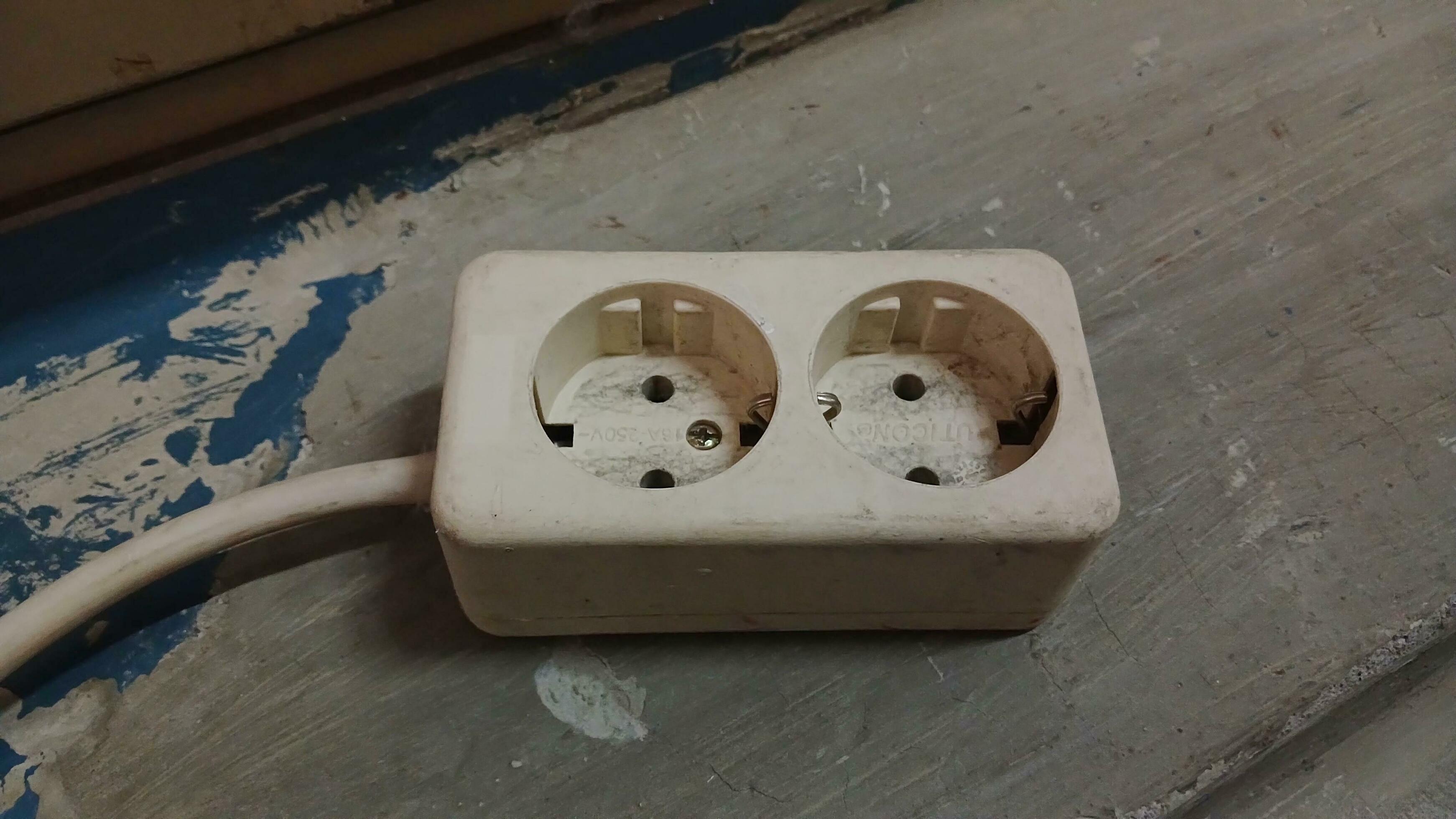 Old electrical socket isolated on gray work floor. Industrial work