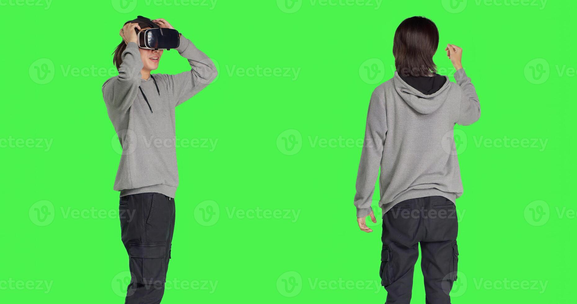 Young guy enjoys virtual reality device in studio with greenscreen background, using interactive vision on glasses. Modern person having fun with artificial intelligence vr headset. photo