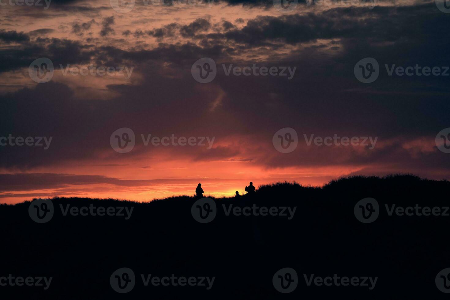 personas en pie en parte superior de el dunas a puesta de sol foto