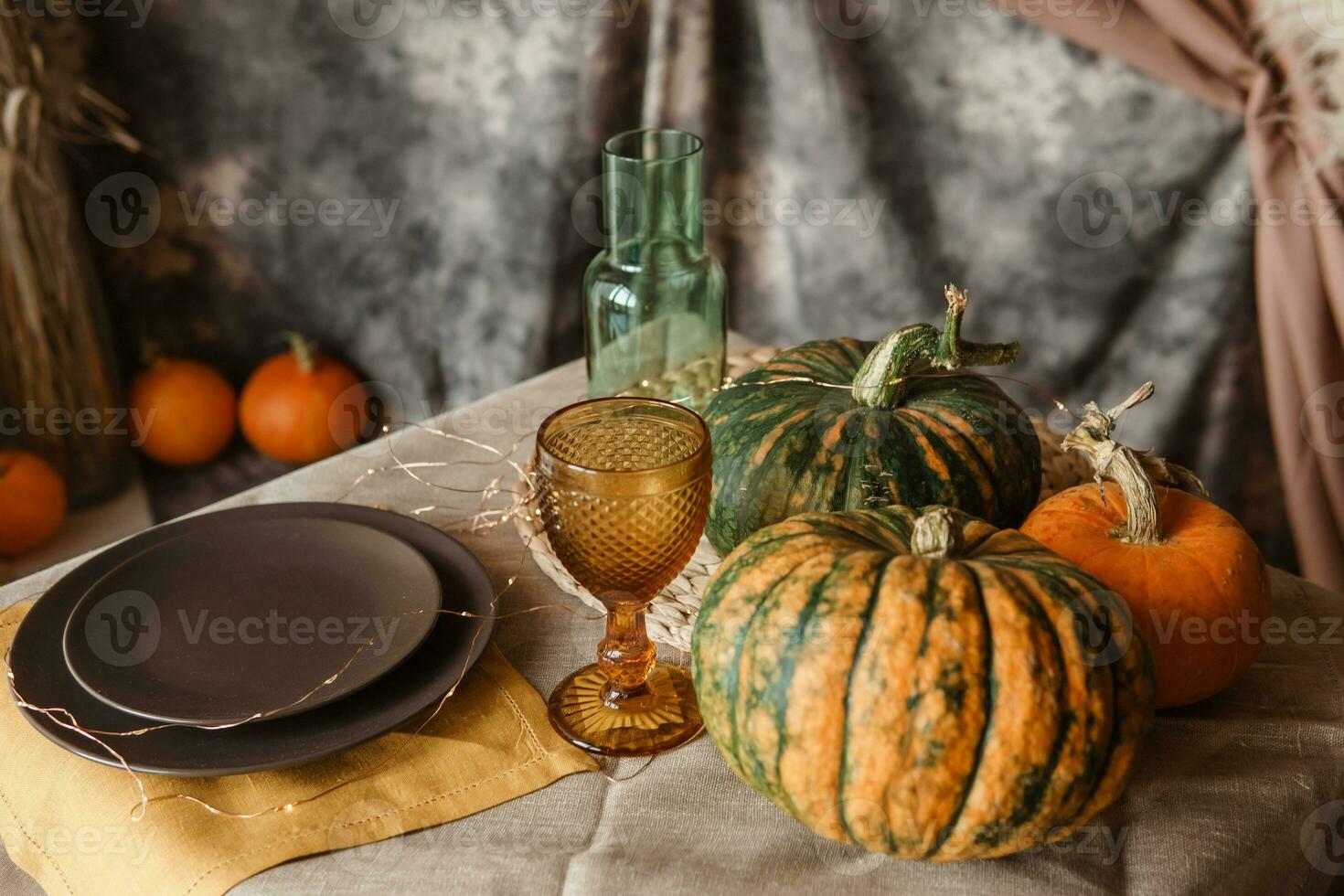 Autumn interior. a table covered with dishes, pumpkins, a relaxed composition of Japanese pampas grass. Interior in the photo Studio. Close - up of a decorated autumn table.