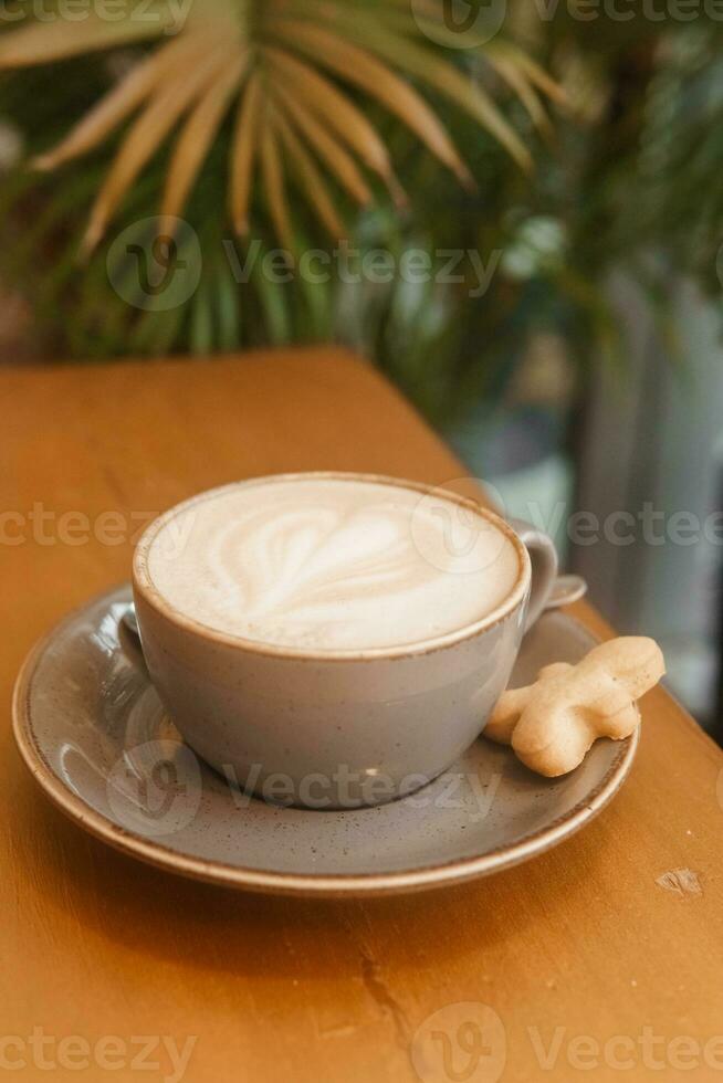 Coffee on a wooden table in a cafe, drawings on coffee. photo