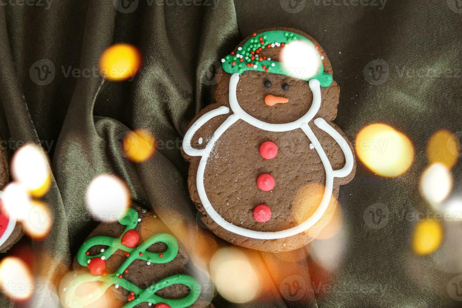 Banner for Christmas and New Year gingerbread. Christmas trees, toys, snowmen, garlands on a background of brown silk fabric. Bright bokeh. photo