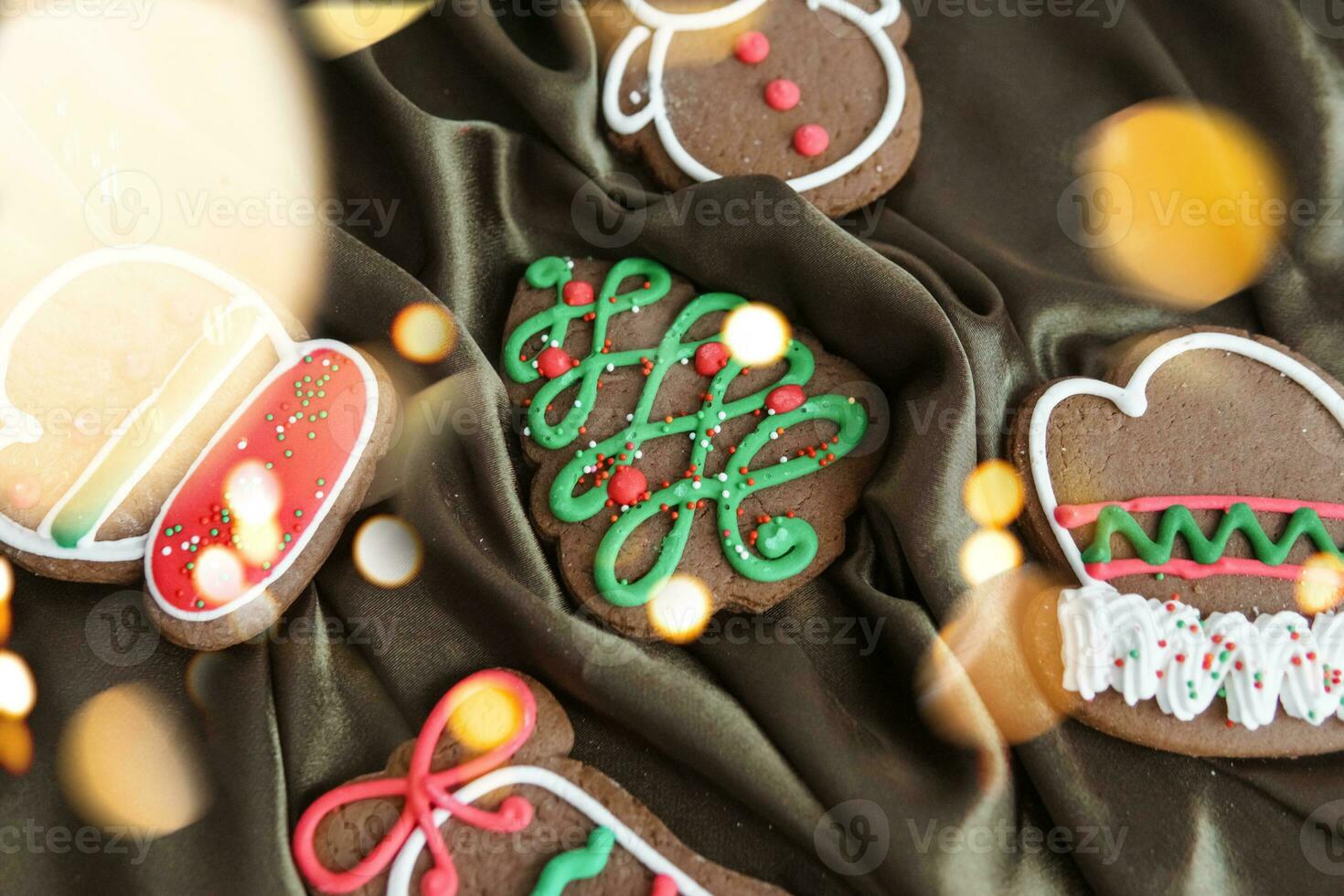 Banner for Christmas and New Year gingerbread. Christmas trees, toys, snowmen, garlands on a background of brown silk fabric. Bright bokeh. photo