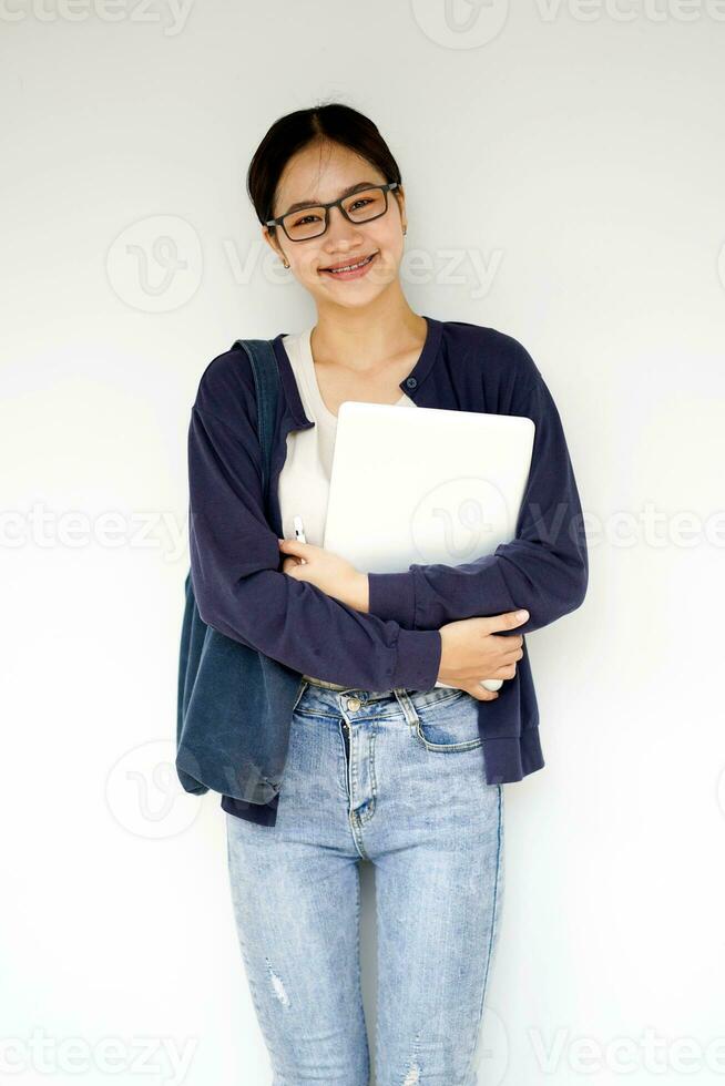 Happiness cheerful Asian young female student in casual cloth holding a laptop on white gradient background. Asian school concept. photo