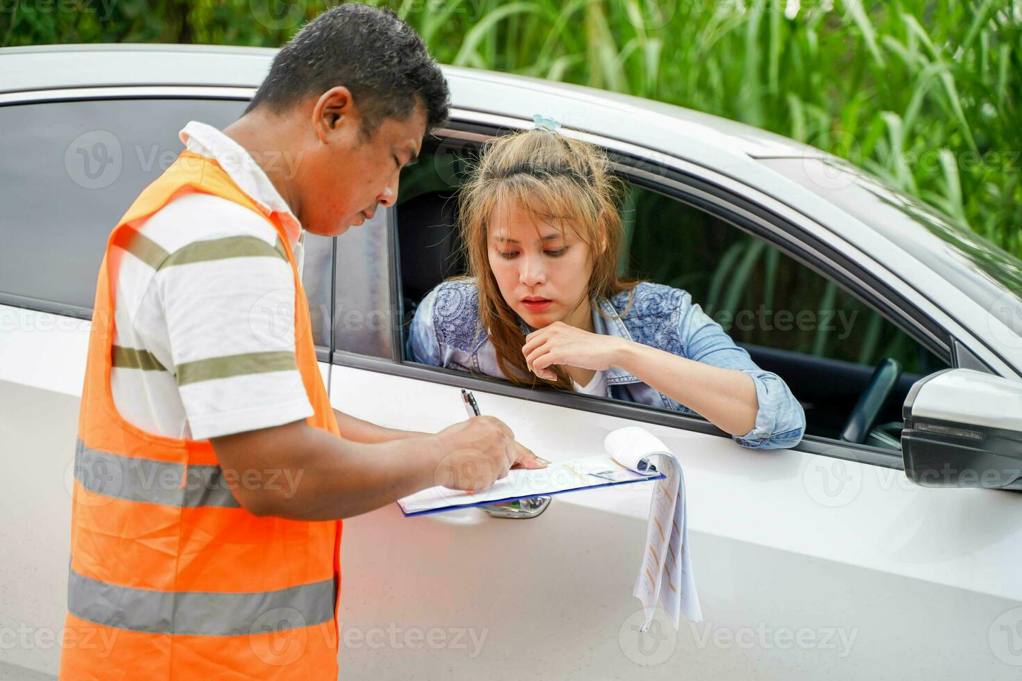 Closeup the insurance company officers write an accident report for customer claim. Traffic accident and insurance concept photo