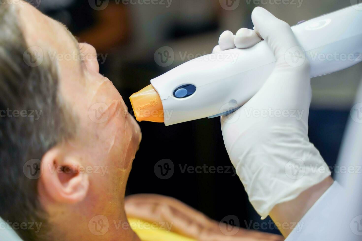 Closeup handsome man having color light therapy to stimulate facial skin wellbeing. photo