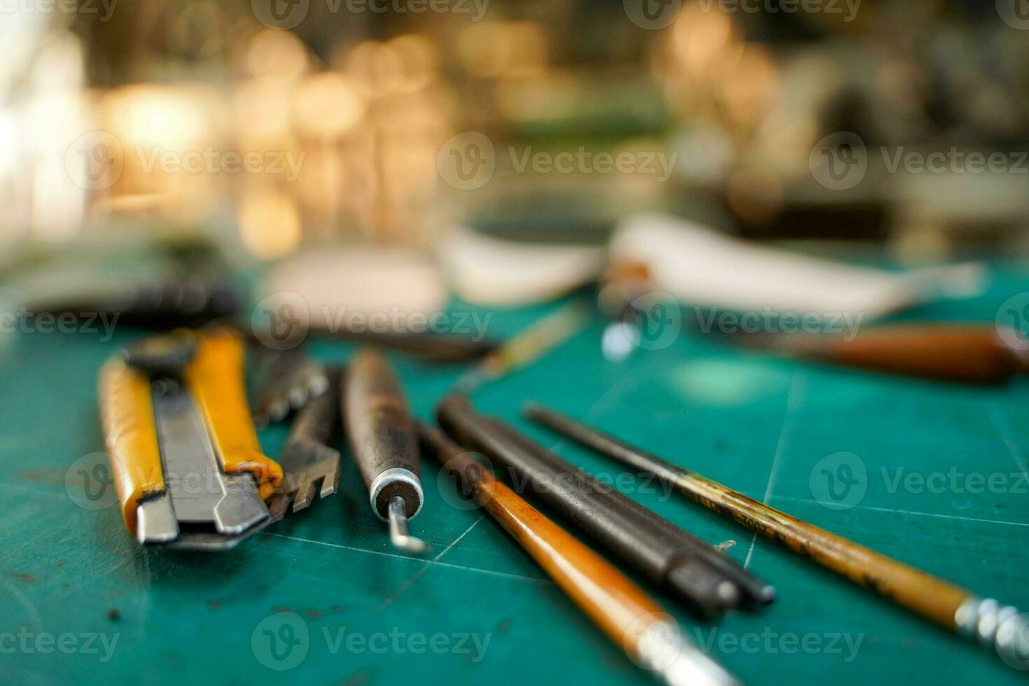 Closeup and crop tools and equipment for leather making on cutting bord and blurred background. photo