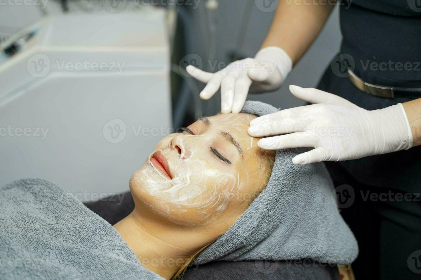 Young beauty woman in towel making facial massage with organic face scrub. photo