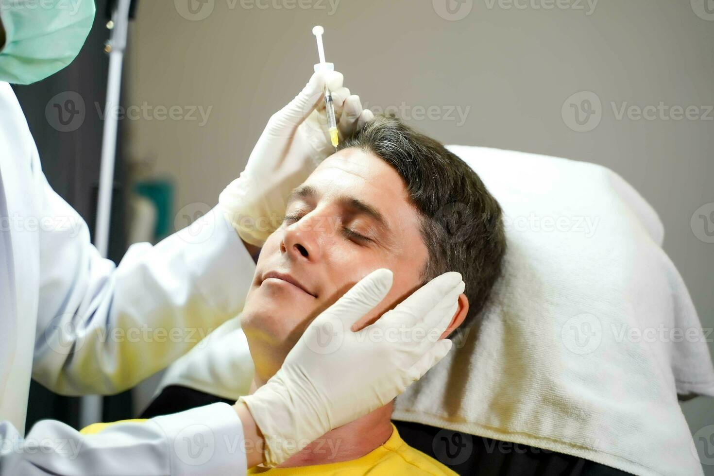 Closeup hands of beauty doctor in medical grove holding beauty skin syringe injecting the customer's face. Beauty skin concept. photo