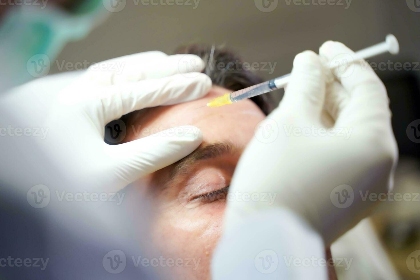 Closeup hands of beauty doctor in medical grove holding beauty skin syringe injecting the customer's face. Beauty skin concept, selective focus on doctor's hand. photo